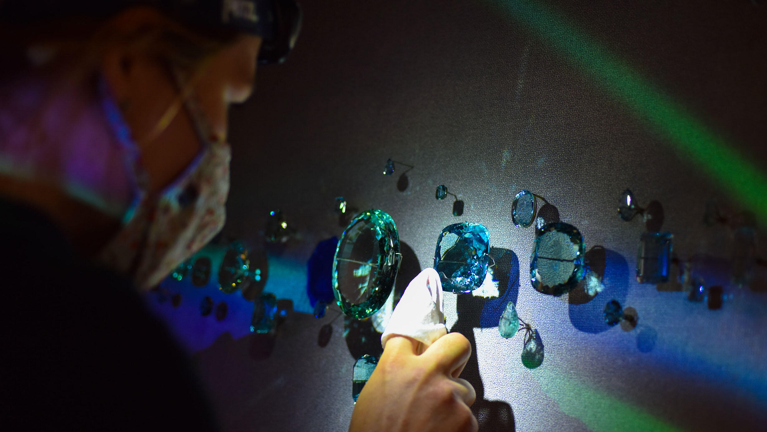 Exhibition staff member polishes gems.