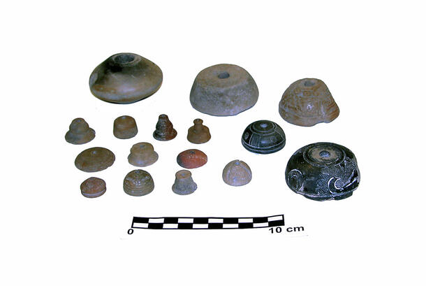 An assortment of 16 small spindle whorls made of ceramic.