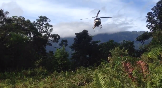Helicopter flying over forest in Guadalcanal