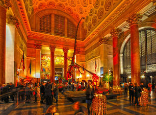 A setting for a private event in the Museum's Theodore Roosevelt Rotunda, its walls awash in colorful shades of light.