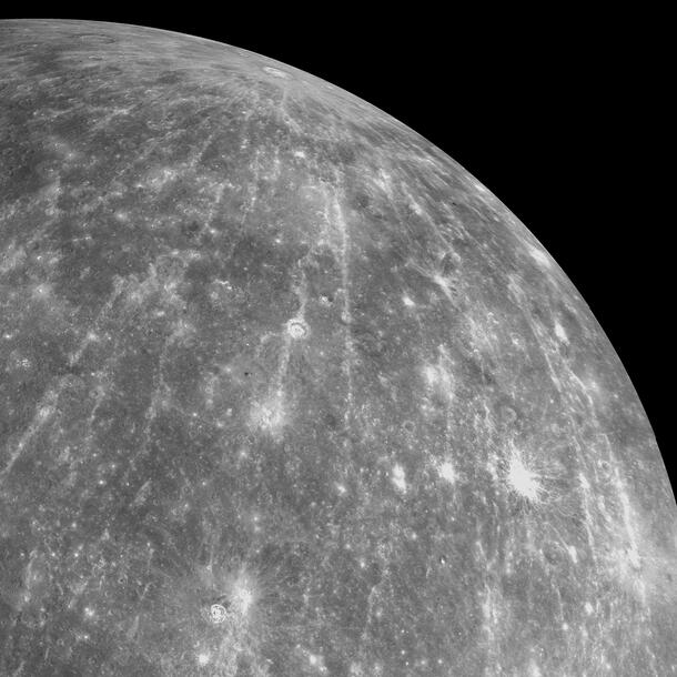 Mercury's surface showing an impact crater and lines fanning out of it.