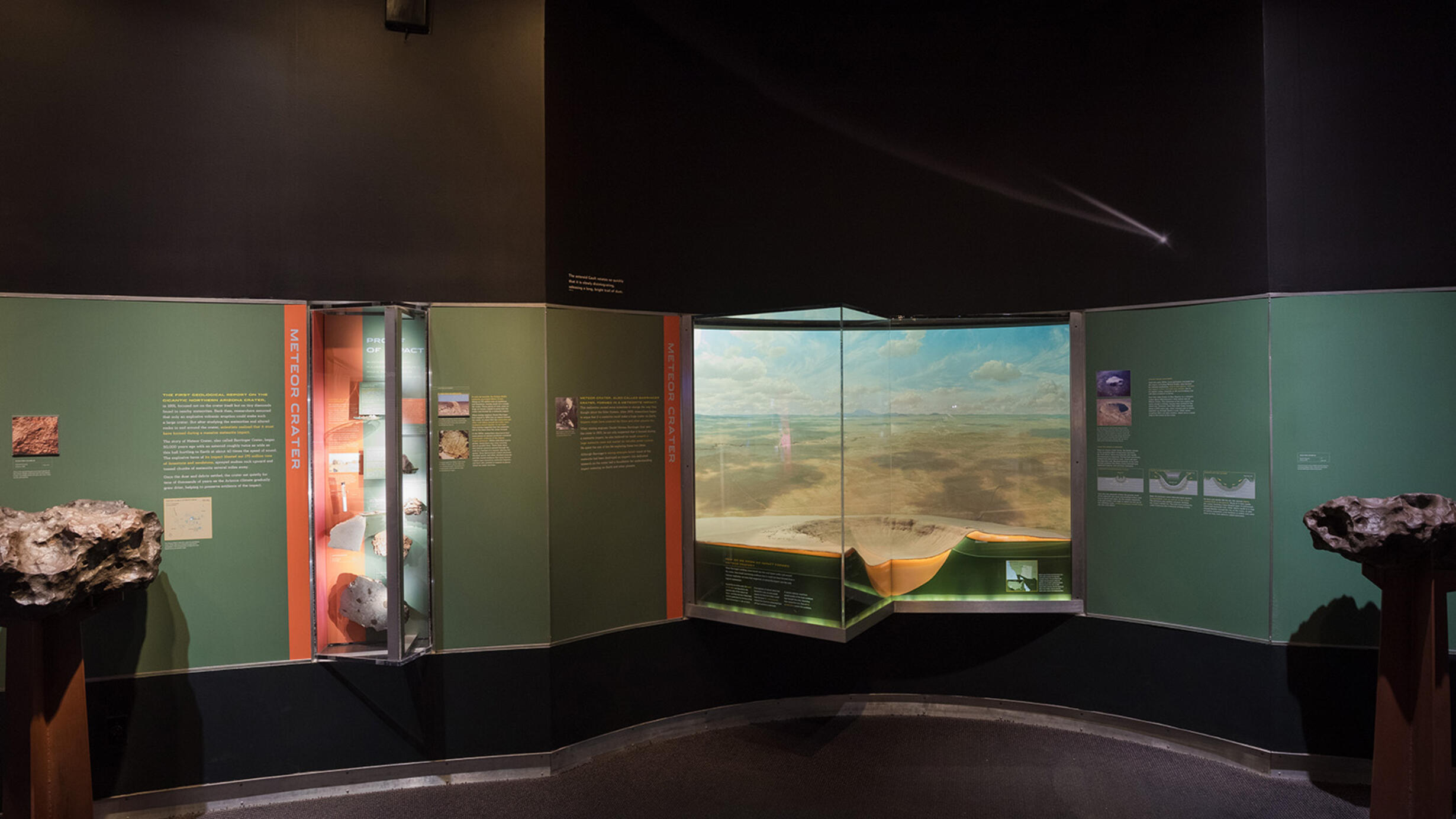 General view of Meteor Crater section in the Hall of Meteorites, showing meteorites, a model of the crater, text and pictures.