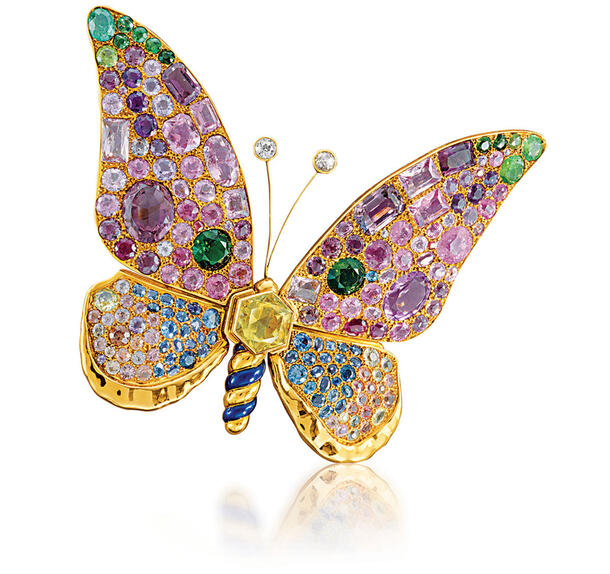 Gold butterfly brooch encrusted with colorful gems.