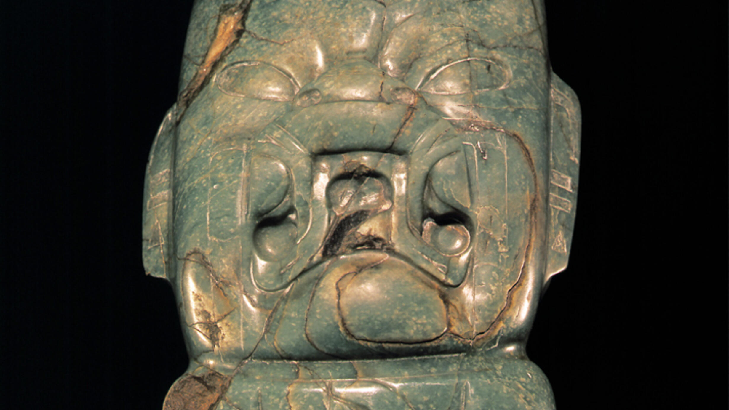 An intricately carved green stone figure.