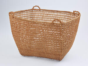 Woven basket with rounded rectangular shape and four small handles at each corner.