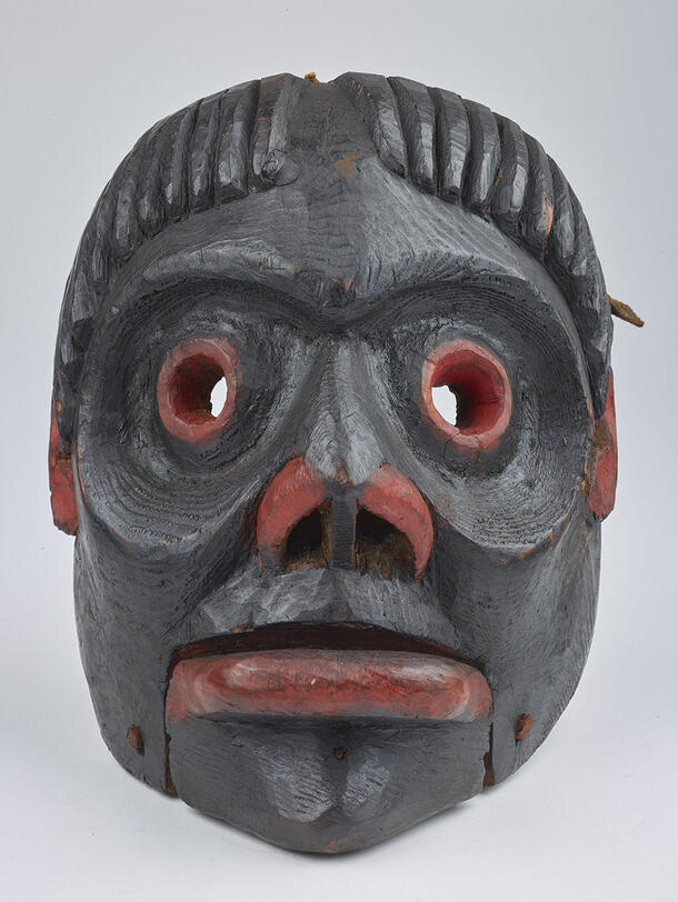 Carved and painted wooden mask depicting a human face.