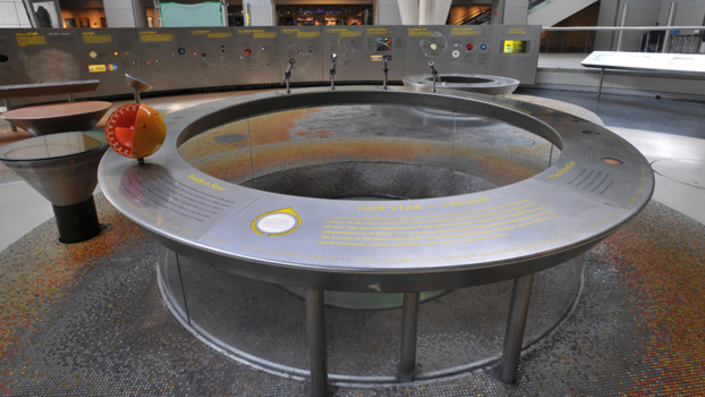 A circular exhibit table in the Cullman Hall of the Universe that features information about the Sun.