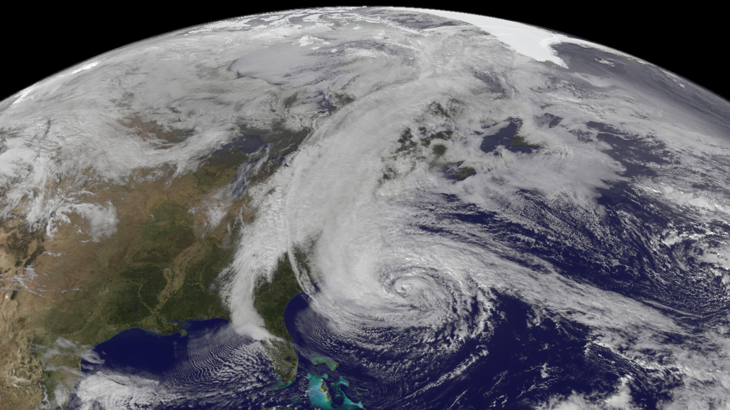 Satellite imagery of swirling white clouds over the east coast of the United States.