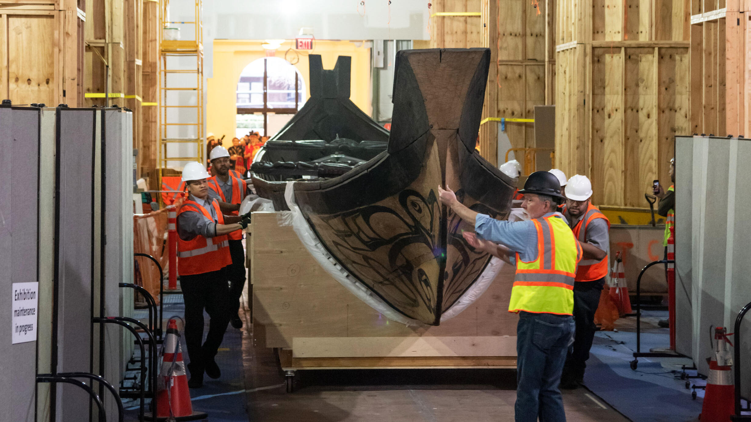 Workmen move the canoe into place in the Northwest Coast Hall.