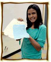 girl holding sheets of hand made paper that she made