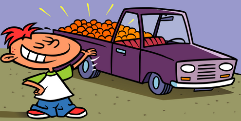 redheaded boy standing in front of a pickup truck with back of the truck full of oranges