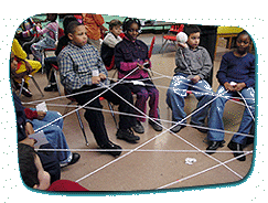 kids sitting in chairs with strings connecting them