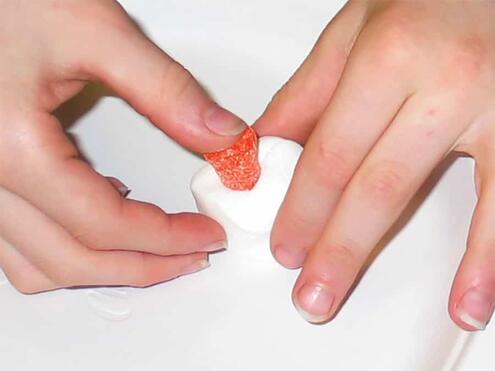 pushing gum drop into the center of the marshmallow