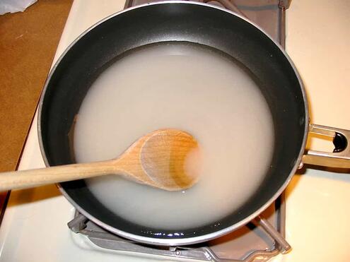 A cloudy mixture of sugar and water in a saucepan