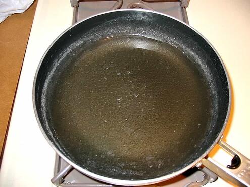 the fully dissolved sugar in water mixture looks clear in the saucepan
