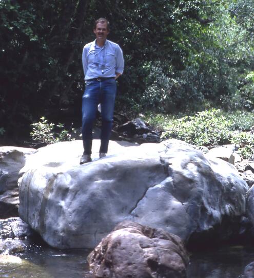 George Harlow standing on large jade boulder in Guatemala in 1984