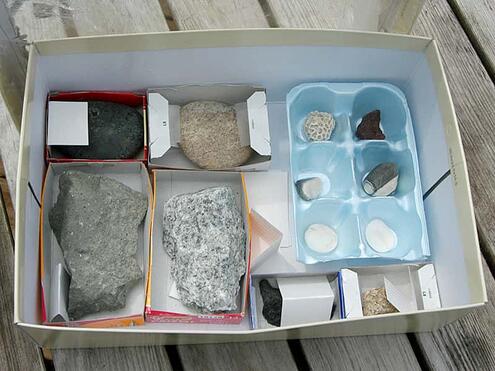 shoebox with smaller containers inside that have rocks in them