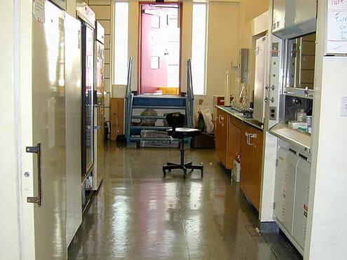 hallway view of cabinets and lab table and chair