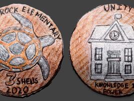 hand drawn coin design with a turtle and words Turtle Rock Elementary with drawing of school on the other side and the word Unity