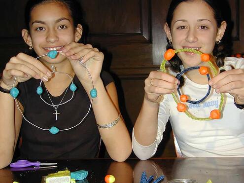 2 girls displaying the completed inner and outer orbits for their mobiles
