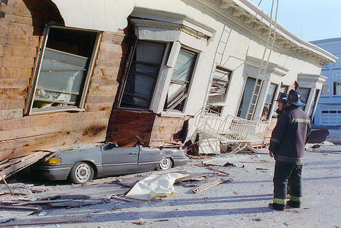 Buildings collapsing on top of a car.