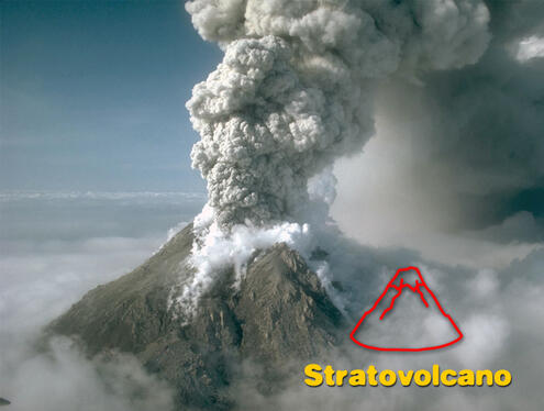 Tall and rocky volcano emitting a very large cloud of ashy smoke