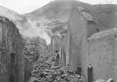 Hovey walking in smoldering ruins on St. Pierre