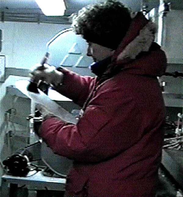 Researcher in a parka handling research materials.
