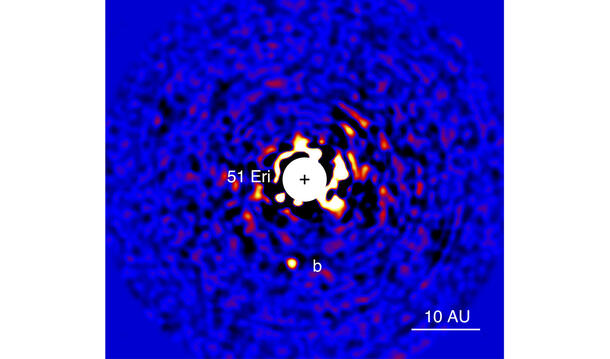Two-toned near-infrared image of a planet with a bright center labeled "51 Eri." and marked with a plus sign within a circle.