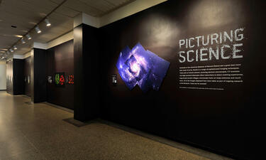 Gráfico del título de la exposición Capturando la Ciencia que incluye una imagen de la galaxia. 