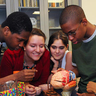 Six students gather around models in the lab.