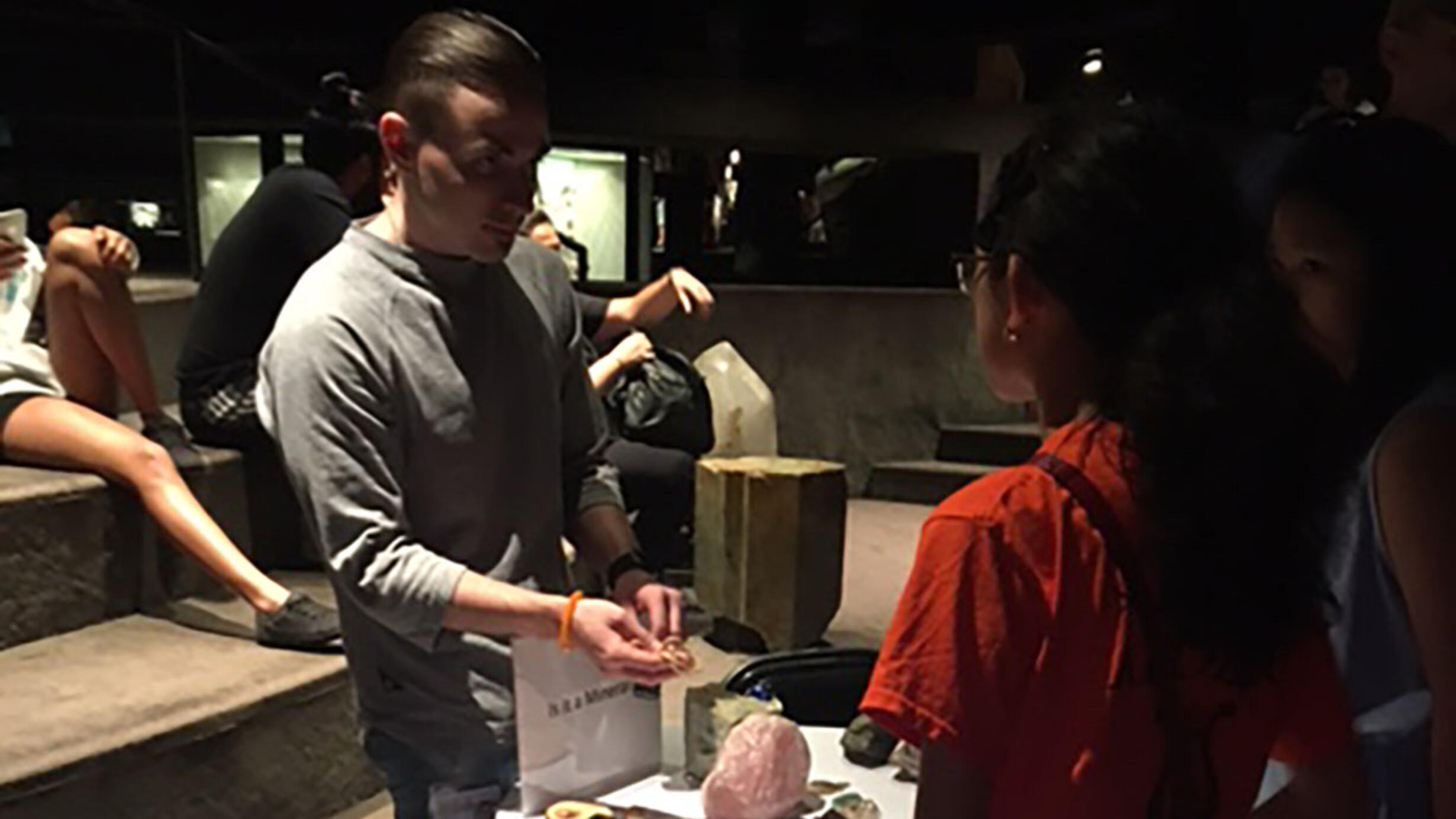 Instructor with student at Mineral display table in the Museum's Hall of Gems and Minerals.