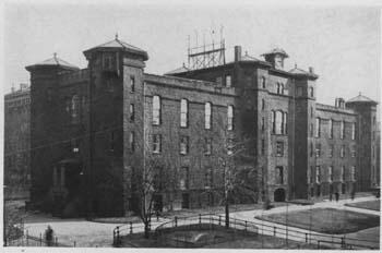 A black and white photograph of an imposing brick building located in what is now Central Park.