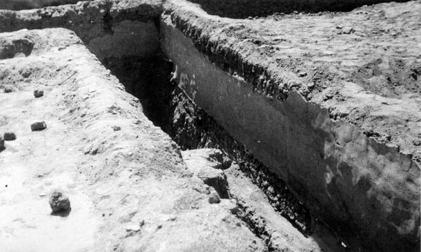 An elongated narrow channel or walkway with steep sides excavated from dry earth. The photo caption states: "North House corridor."