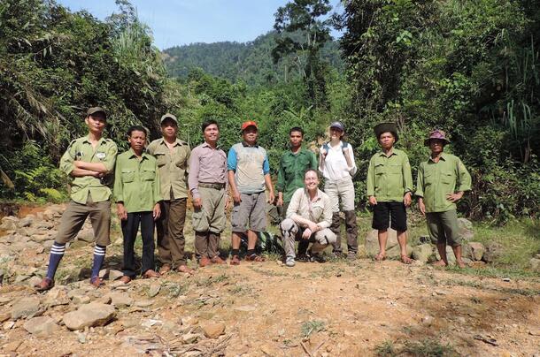 Mary Blair with Vietnamese park rangers posing for photo in Vietnam forest edge