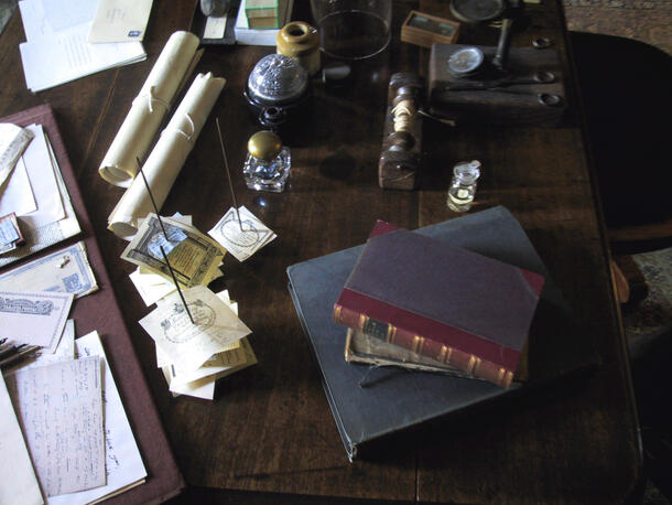 Image of a few books, a few papers and other stationary on Charles Darwin's desk in his study