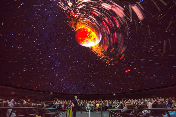 Brian Abbott presenting the moon formation sequence to an audience in the planetarium.