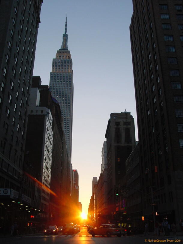 The sun setting on 34th street in New York City, framed by buildings in the twice-annual event known as Manhattanhenge.