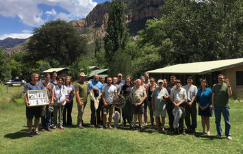  A group of 23 researchers pose for a group portrait outdoors at the Southwestern Research Center.