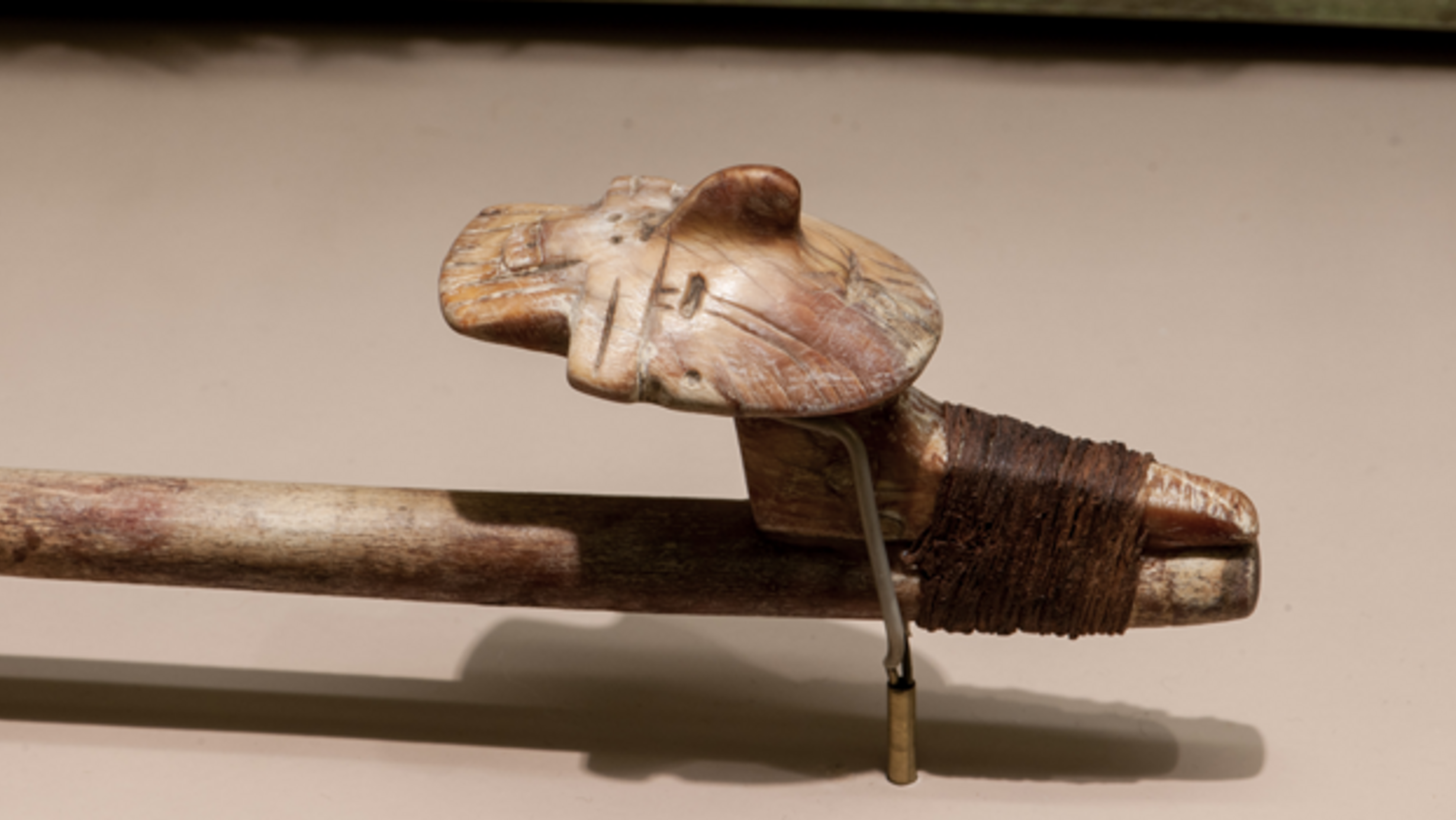 At the end of the rod of this spear-thrower is a human head, finely-carved with a prominent nose.