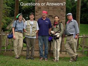 Five people standing outdoors at the Archaeological Park and Ruins of Quirigua in Guatemala, in front of a massive ornately carved stela.