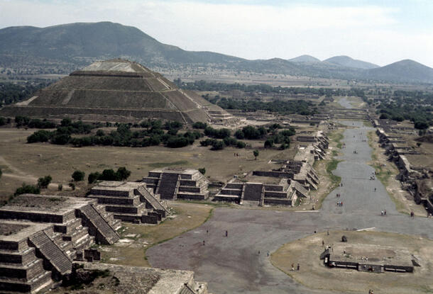 A wide shot of the Teotihuacan complex showing a row of pyramids and a wide avenue.