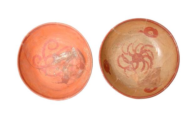 Two shallow bowls with painted designs.