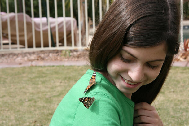 2011 Young Naturalist Award winner Katelyn, 12, with two Painted Lady butterflies on her shoulder