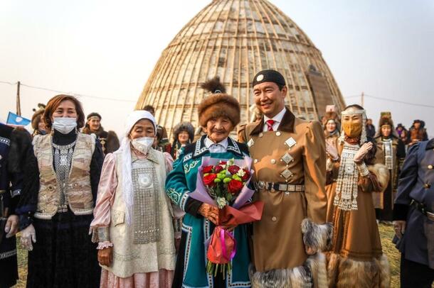  A large group of people stands outside of the newly constructed Yakut (Mo5ol-Uraha).