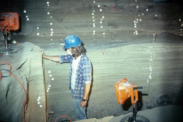 Man with hard hat with lights exploring Hidden Cave in Nevada as part of 1978-79 Museum research into cave used by humans in late Archaic period