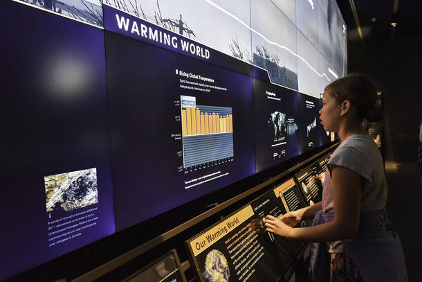 Young visitor looks at a digital display about climate change in the Museum's Hall of Planet Earth.