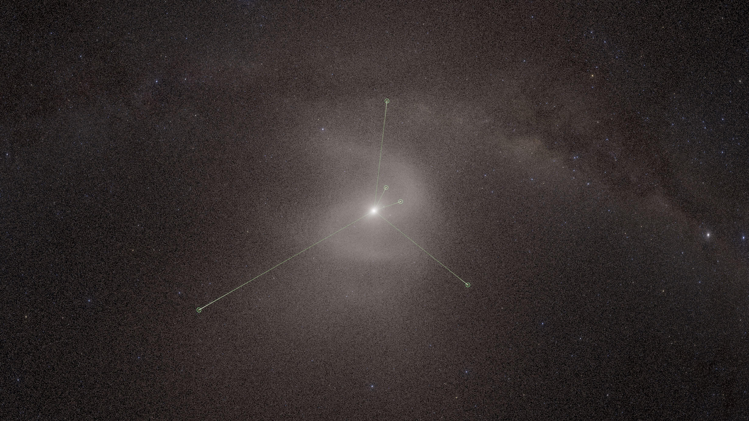A dusty, backwards S-shape behind the Sun with three bright lines pointing outward from the Sun into dark, cloudy space.