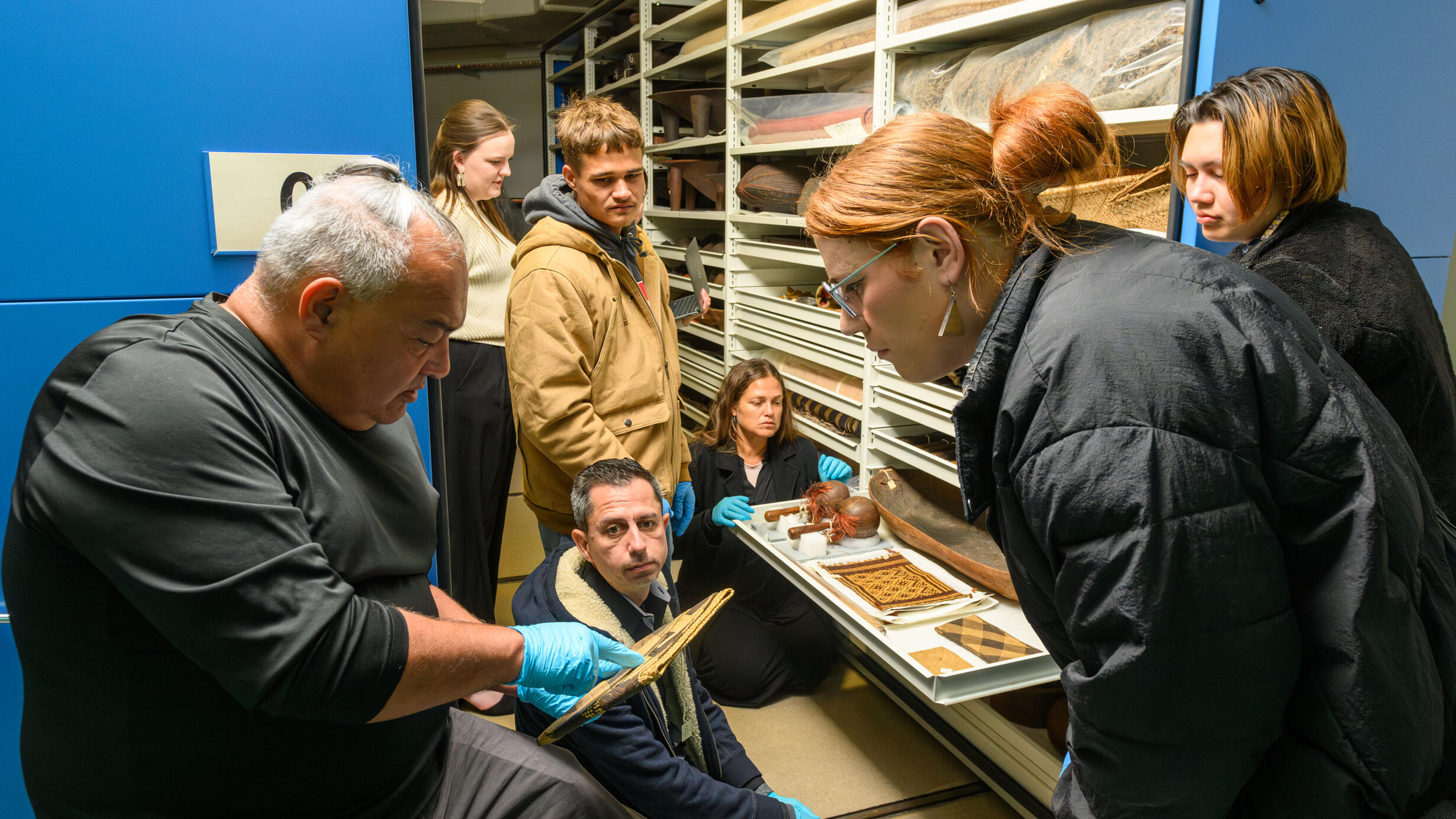Members of the Hawaiian delegation view items in the Museum’s Pacific ethnographic collection, including examples of basketry accessioned in 1900. 