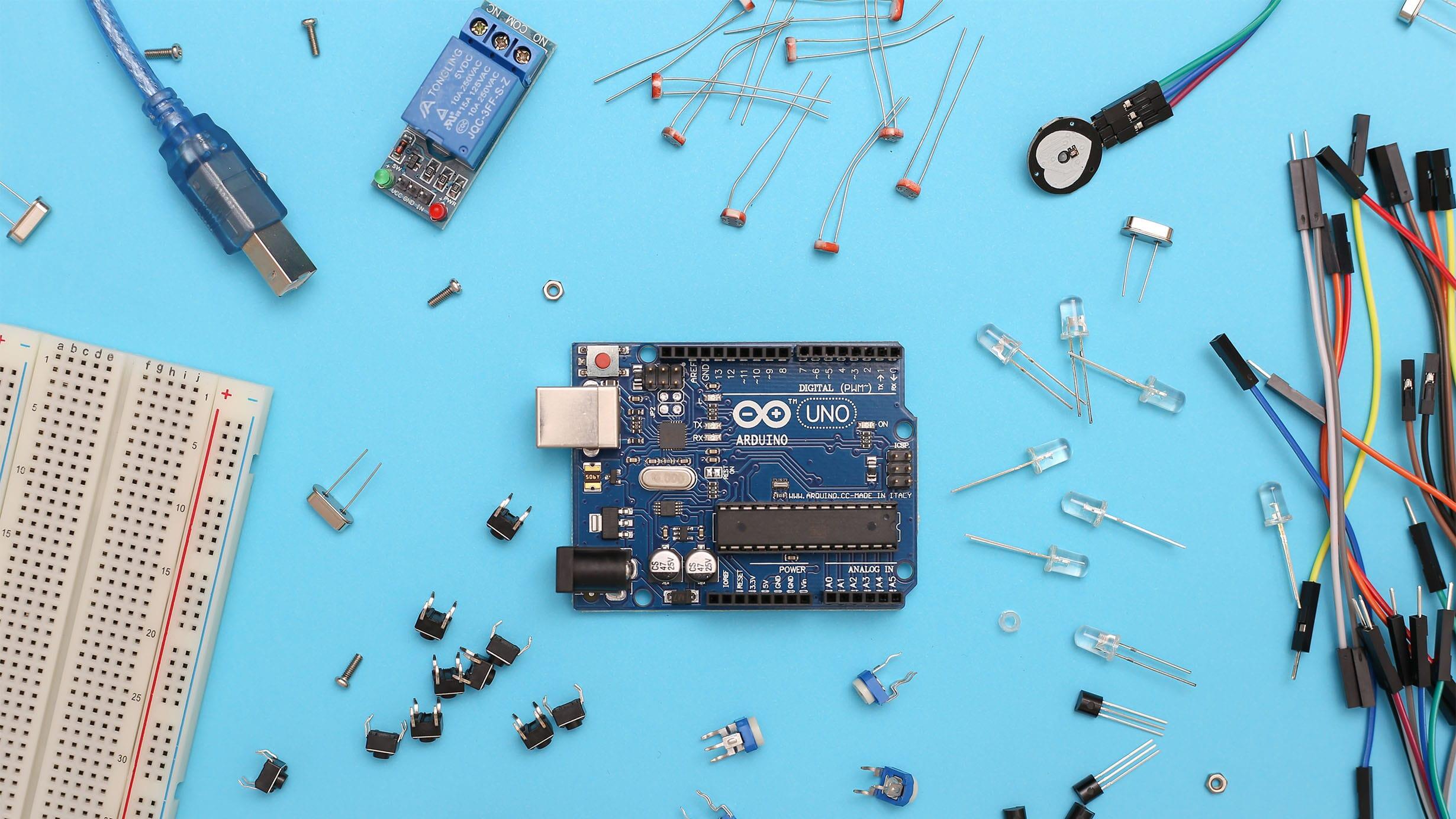 A close up photograph of a microchip, with assorted elements - transistors, diodes and the like - scattered around.